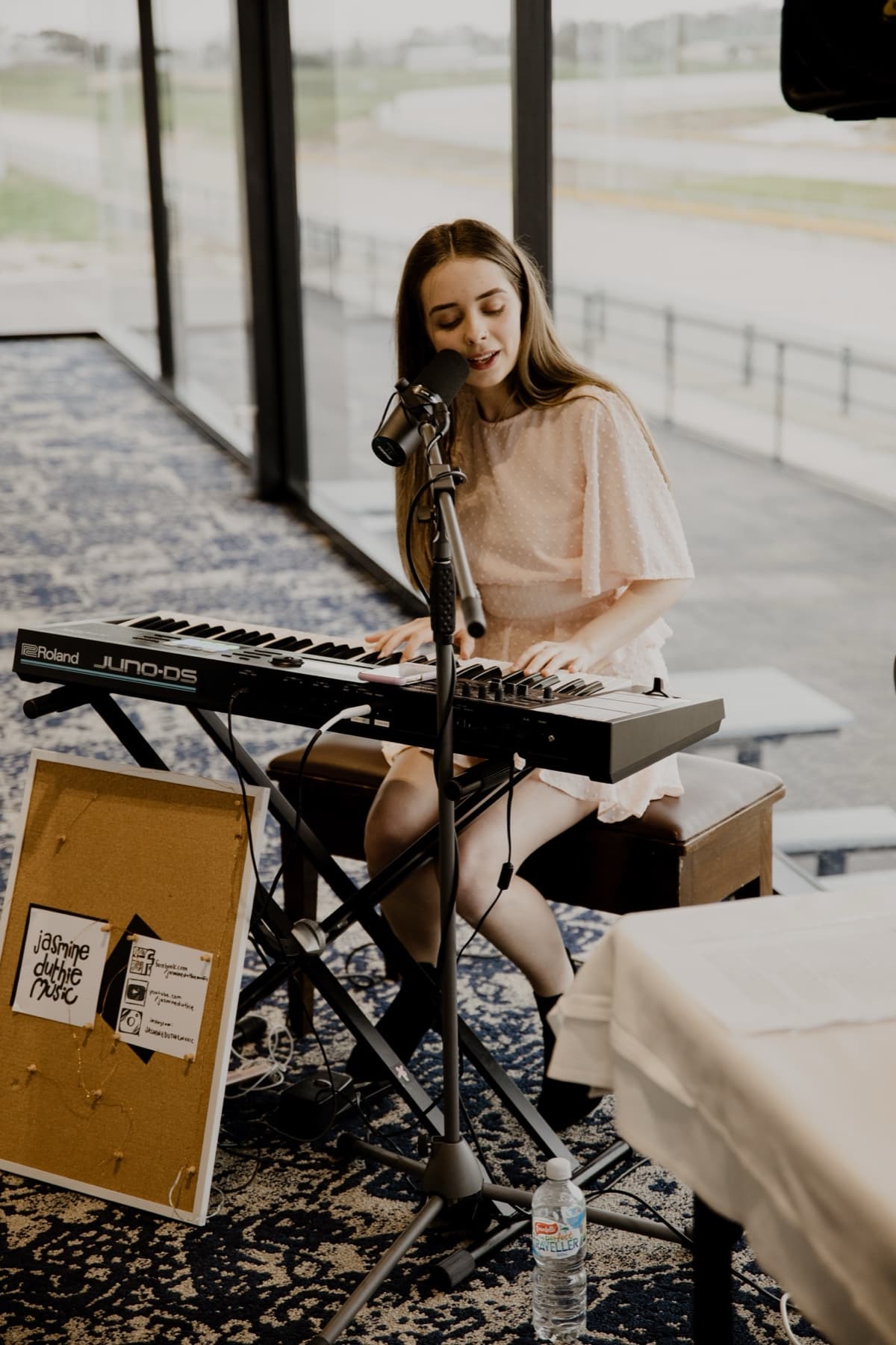 Jasmine singing live behind a Roland keyboard