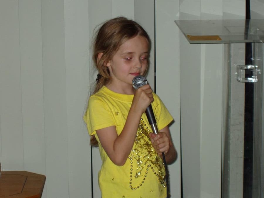 Young Jasmine singing into a mic